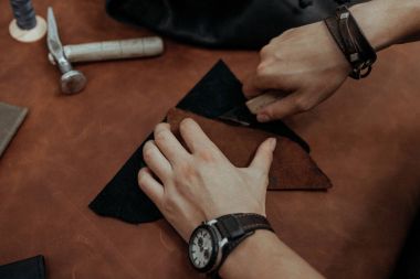 Yakın plan. Bıçakla deri ürünlerine doğranmış bir erkek el ustası. Küçük işletme