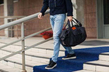 Genç adam bir çanta ile aşağı geliyor. Yakın çekim