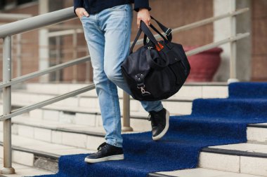 Genç adam bir çanta ile aşağı geliyor. Yakın çekim