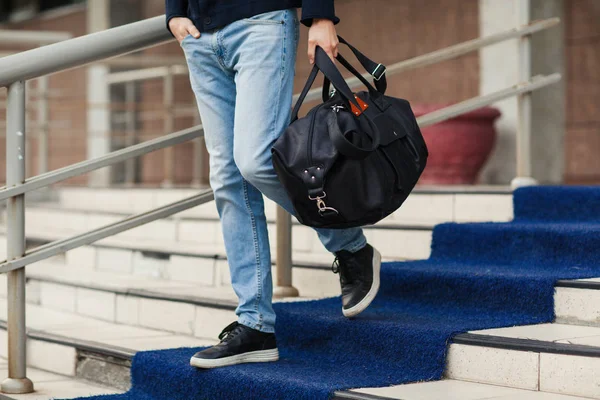 Genç adam bir çanta ile aşağı geliyor. Yakın çekim