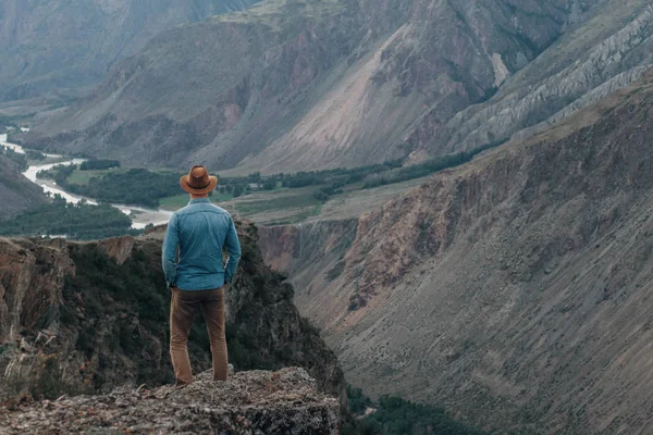 Bir şapka Gezgin yüksek rock kenarında maliyeti ve bir kanyon Vadisi'ne görünüyor — Stok fotoğraf