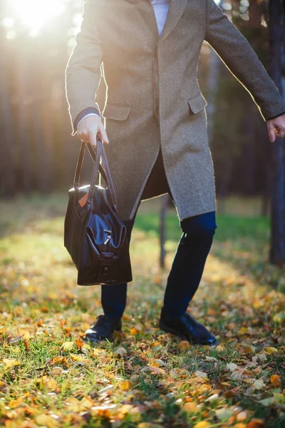 Nahaufnahme des Mannes läuft mit einer Tasche auf das Holz — Stockfoto