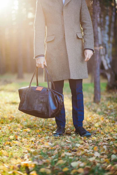 Paltolu adam ve bir deri çanta güzel sonbahar ahşap kadar Clous