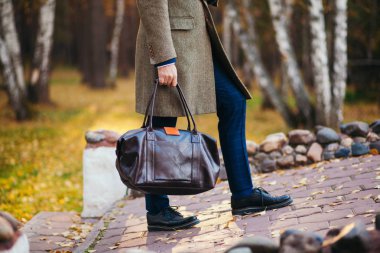 Evrak çantası ile sokakta yürüyen meşgul adam