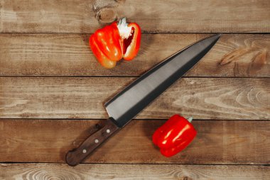Aralarında bir mutfak bıçağı ile ahşap bir parça üzerinde iki kırmızı biber