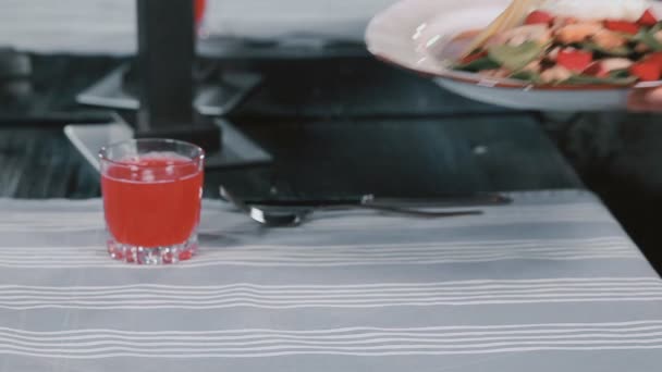 Garçom coloca uma placa com salada em uma mesa — Vídeo de Stock