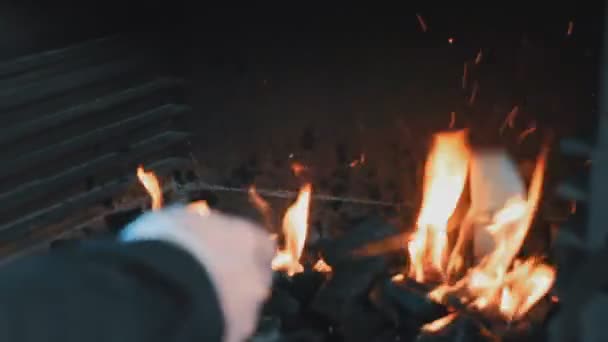 O homem mistura carvão em um braseiro — Vídeo de Stock