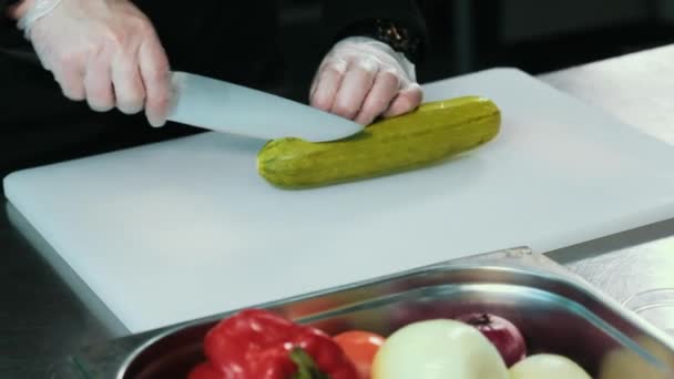 FECHAR ALIMENTOS: chef cortado abobrinha verde em uma placa branca — Vídeo de Stock