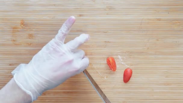 Chef corte cortando tomates cereja em uma placa de corte de madeira. Vista superior . — Vídeo de Stock