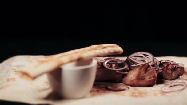 食べ物を Clouse。既製のシシカバブ。ピタパンとソースのシートにてタマネギとハーブ、豚肉からシシカバブ. — ストック動画