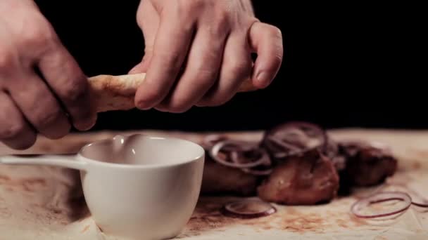 Розкласти їжу. Рука рве питу лаваша. На фоні лежить шашлик з цибулею та кільцями . — стокове відео