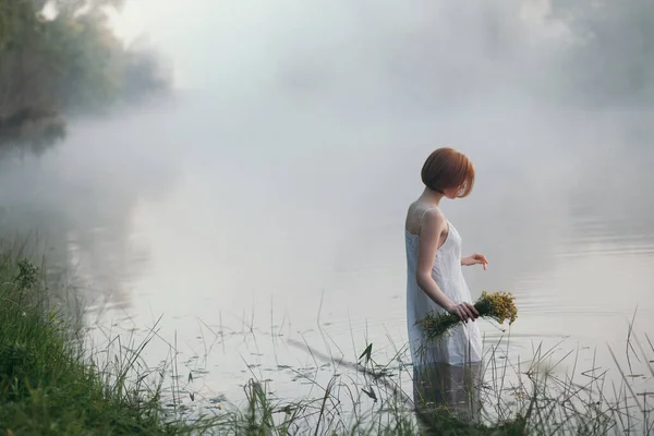Flicka med kort hår stående i dimmig sjö — Stockfoto