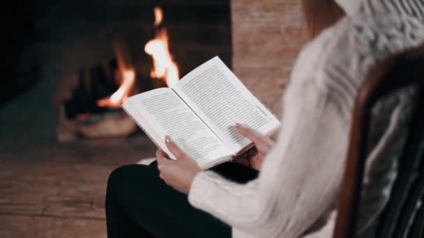 Mulher livro de leitura perto de lareira feita de tijolos — Vídeo de Stock