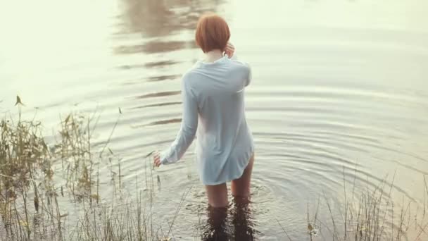 Ragazza con i capelli rossi in piedi camicia vestita nel lago — Video Stock