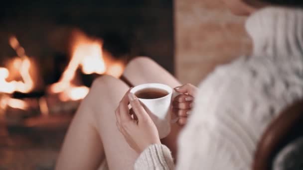 Närbild till kopp te kvinnor hand öppen spis i bakgrunden — Stockvideo