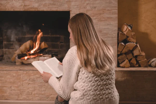 Woman with book near by the brick fireplace — Stock Photo, Image