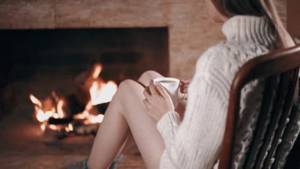 Dívka polonahá v bílém svetru v blízkosti krbu — Stock video