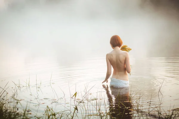 Halvnaken attraktiv kvinna stående i dimmig sjö — Stockfoto