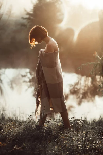 Beautiful young woman walking in grass by the lake — Stock Photo, Image