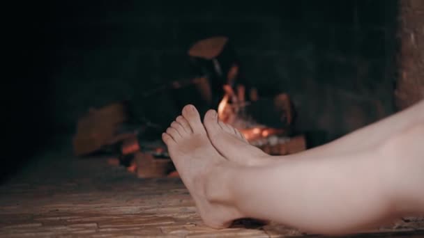 Закройте женские ноги у камина — стоковое видео