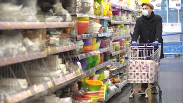 Muž v ochranných rukavicích kupovat toaletní papír v obchodě. — Stock video