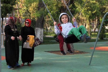 Ashgabad, Türkmenistan - 9 Ekim 2014: İran giysili iki kadınla parkta çocuklar