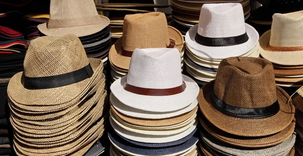 Una varietà di cappelli da uomo estivi in un mercato di strada . — Foto Stock