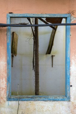 terk edilmiş bir evde - dikey bir turuncu duvar eski ahşap mavi pencere çerçeve