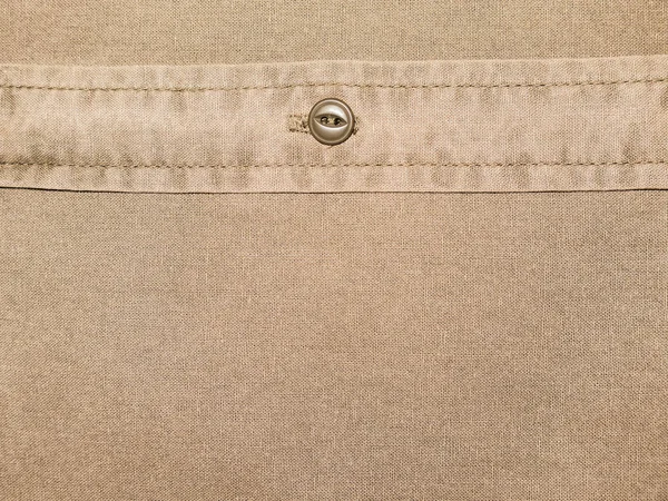 plain brown cotton shirt texture with button in close up