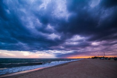 Sahilde günbatımı, fırtına