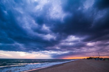 Sahilde günbatımı, fırtına