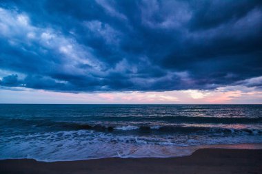 Sahilde günbatımı, fırtına