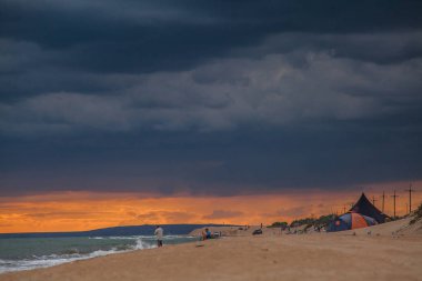 Sahilde günbatımı, fırtına