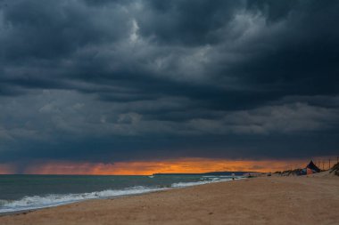 Sahilde günbatımı, fırtına