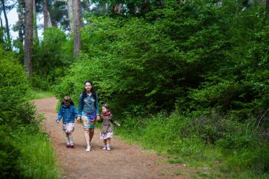 Anne ve iki kızı ormanın yol boyunca yürüyüş