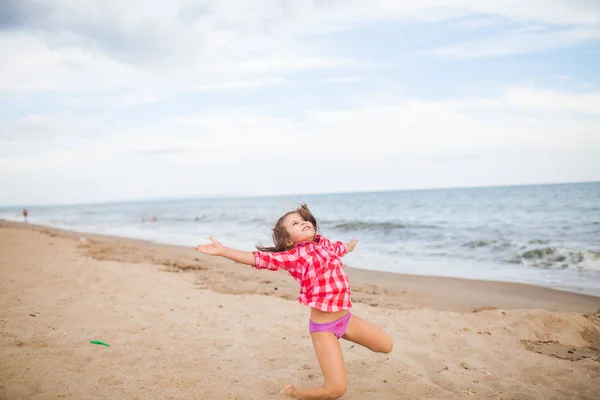 Mladá dívka v košili hraje na písečné pláži — Stock fotografie