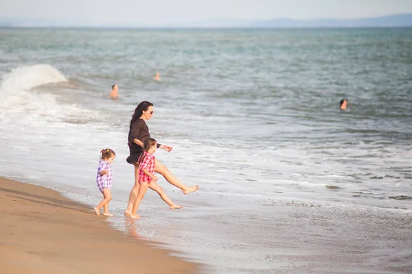kumlu sahilde sörf ile oynarken iki kızı annesiyle