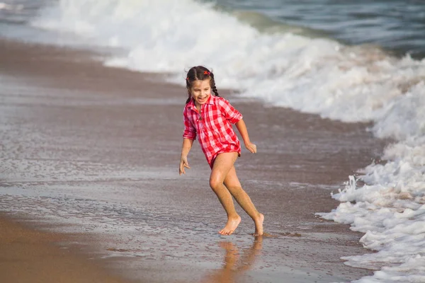 Chica joven en camisa juega con el surf y huir de las olas —  Fotos de Stock