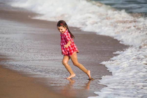 Chica joven en camisa juega con el surf y huir de las olas —  Fotos de Stock