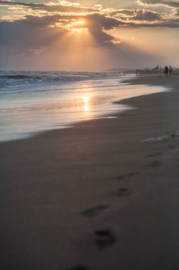 gün batımında kum plajındaki ayak izleri