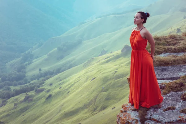 悬崖边上穿红色连衣裙的女人 — 图库照片