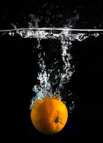 Fresh orange falling in water — Stock Photo, Image