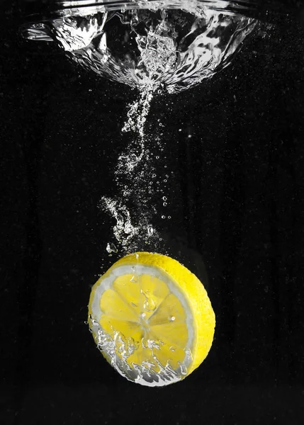 Fresh lemon falling in water — Stock Photo, Image