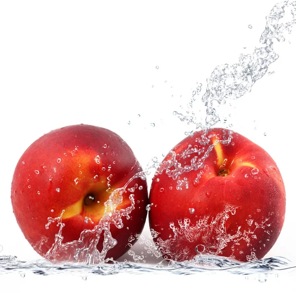 Персик падает в воду — стоковое фото