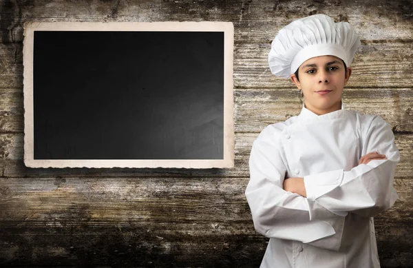 Mladý kuchař s panelem pro menu — Stock fotografie