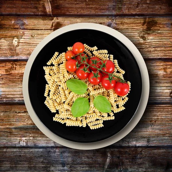 Piatto con pasta cruda italiana e ingredienti — Foto Stock