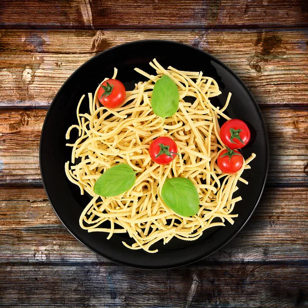 Piatto con pasta cruda italiana e ingredienti — Foto Stock