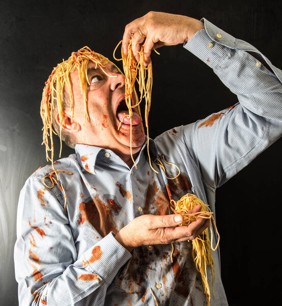 man eating spaghetti with tomato sauce in head
