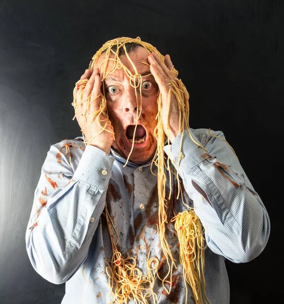Άνθρωπος τρώει μακαρόνια με σάλτσα ντομάτας στο κεφάλι — Φωτογραφία Αρχείου