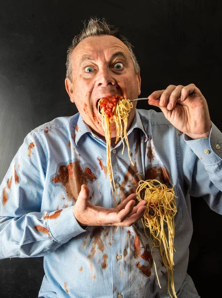 Hombre comiendo espaguetis con salsa de tomate — Foto de Stock